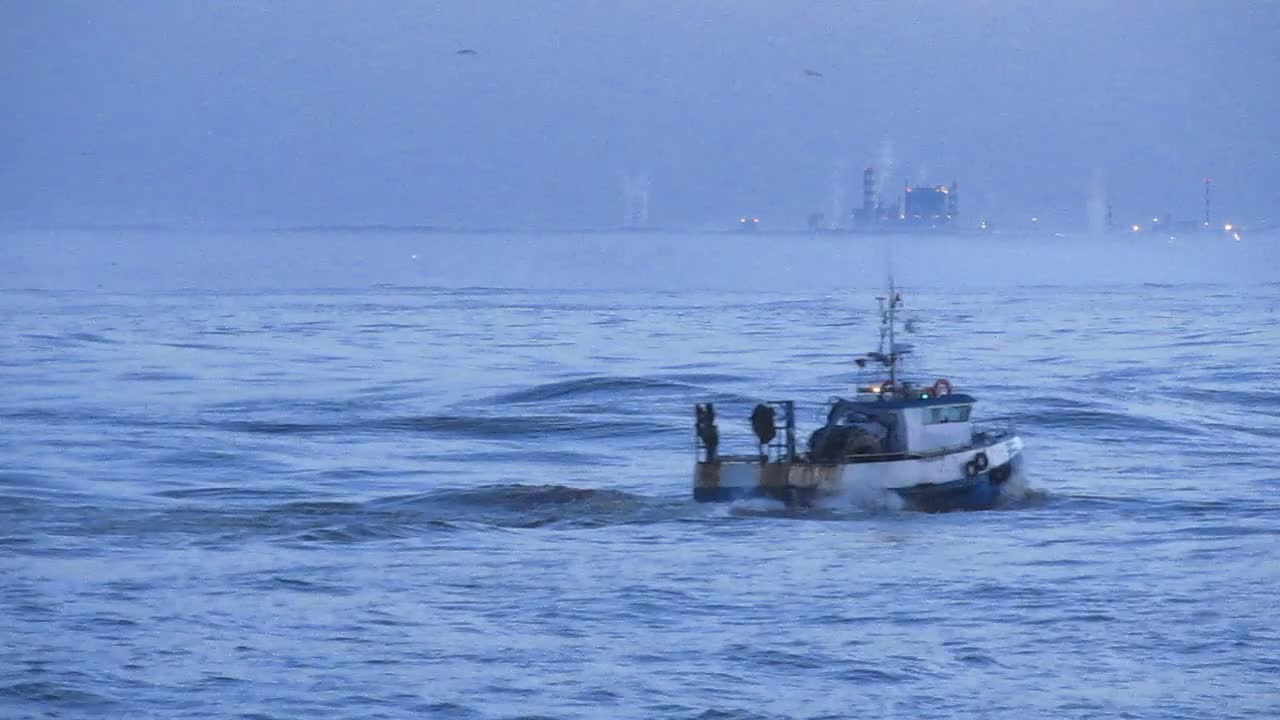 Trawler under the waves in the seasea.