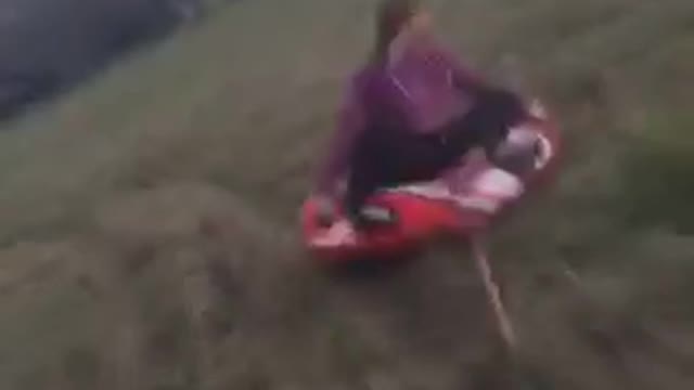 Girl falls off red tube pulled by four wheeler