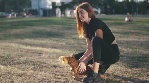 Young beautiful woman in the park with her funny long-haired chihuahua dog