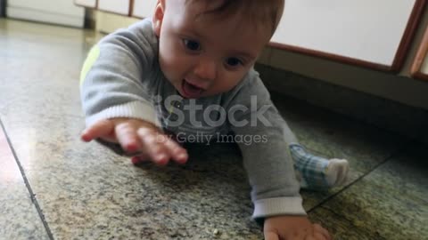 Funny baby playing in the kitchen.