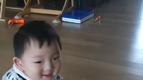 This is a video of a baby practicing standing for the first time.