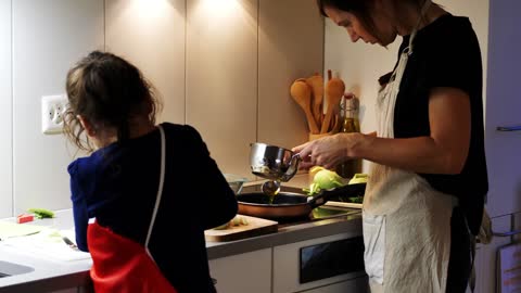 A Girl Is Placing Topping On A Cake