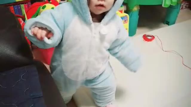 A baby in a blue bear suit