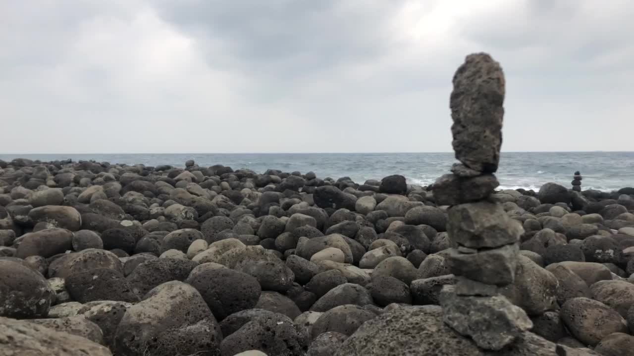 a stone pagoda piled up on the Jeju Island beach