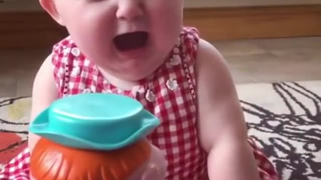 Funny laughing baby scared by gift toy - baby laughing