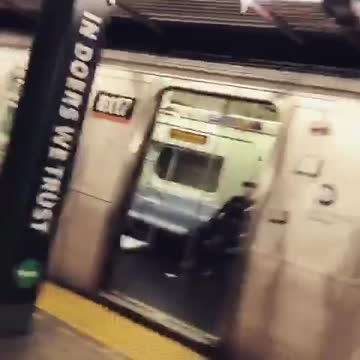Guy in latex green unitard streaming iphone stand subway