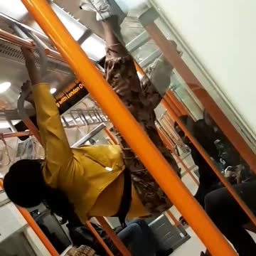 Yellow jacket woman hangs from subway poles