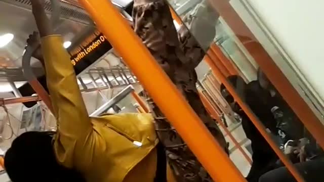 Yellow jacket woman hangs from subway poles