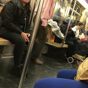 Guy listens to music and dances by himself on subway train