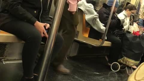 Guy listens to music and dances by himself on subway train