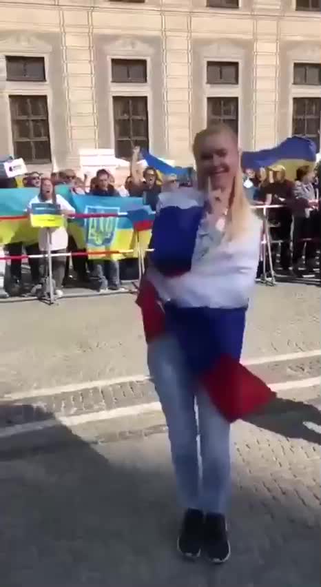 Odvážná demonstrantka s ruskou vlajkou proti žlutomodré záplavě