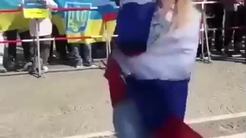 Odvážná demonstrantka s ruskou vlajkou proti žlutomodré záplavě