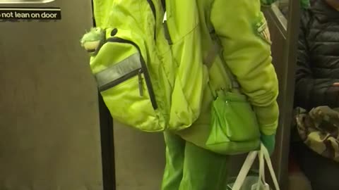 Yellow backpack woman stands really close to seated man