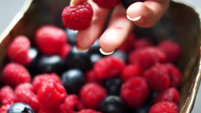 Filling a Bowl With Red Berries