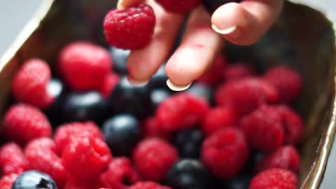 Filling a Bowl With Red Berries