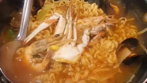 Seafood ramen eaten at the seaside, blue crab, shrimp, mussel, spicy Korean ramen