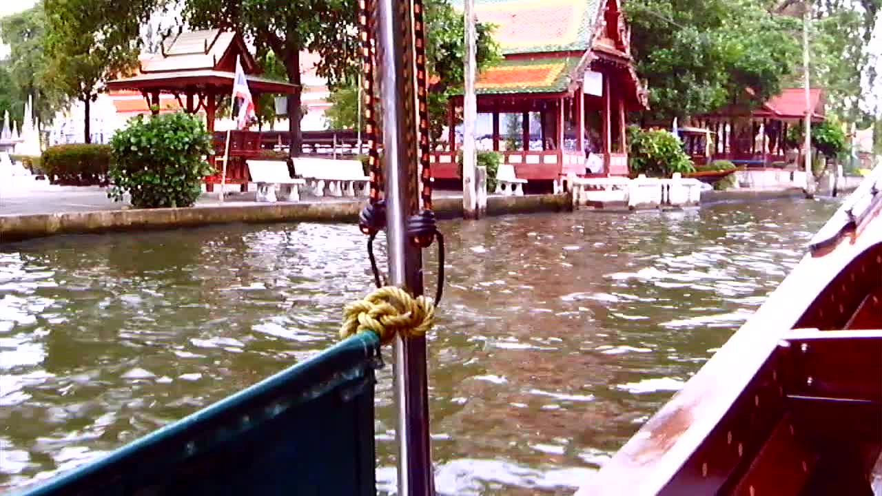 FEEDING THE "SACRED FISH" OUTSIDE A THAI TEMPLE ON THE WATER