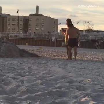 Guy in neon green shorts takes picture of friend jumping off rocks