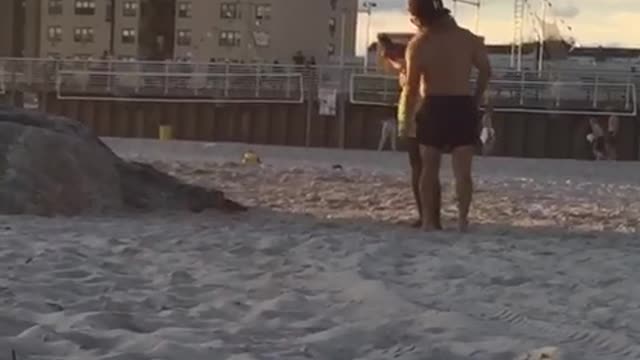 Guy in neon green shorts takes picture of friend jumping off rocks