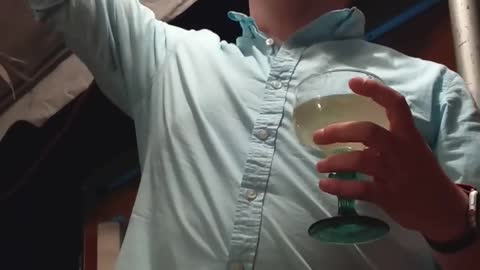 Drunk guy blue button up shirt singing idgaf with margarita drink in hand