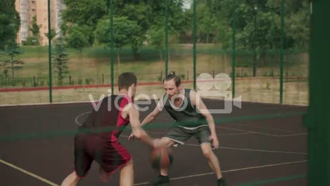 Two Active Sportsmen Playing In An Outdoor Basketball Court 1