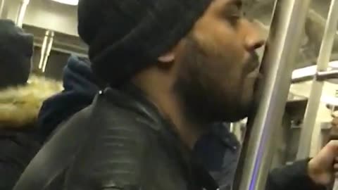 Man black jacket kissing subway pole