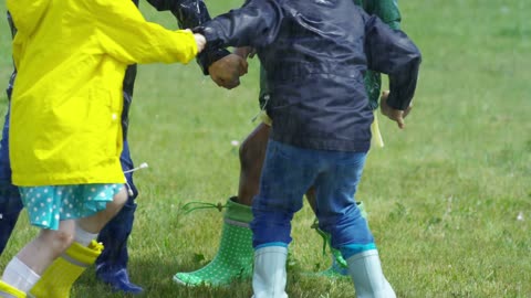 Children Playing In A Park Getting Wet By The Rain