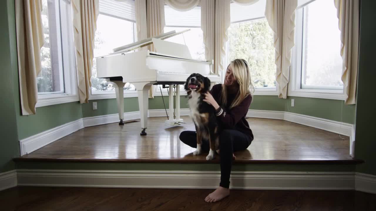Pretty Blonde Woman and Her Dog Sitting at Home in Well Lit room