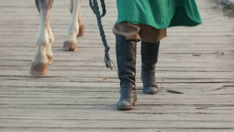 Person in boots leading a horse. Festival of Medieval culture. Park Kievan Rus