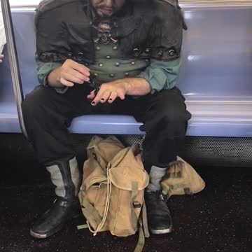 Man dressed as pirate doing nails on subway