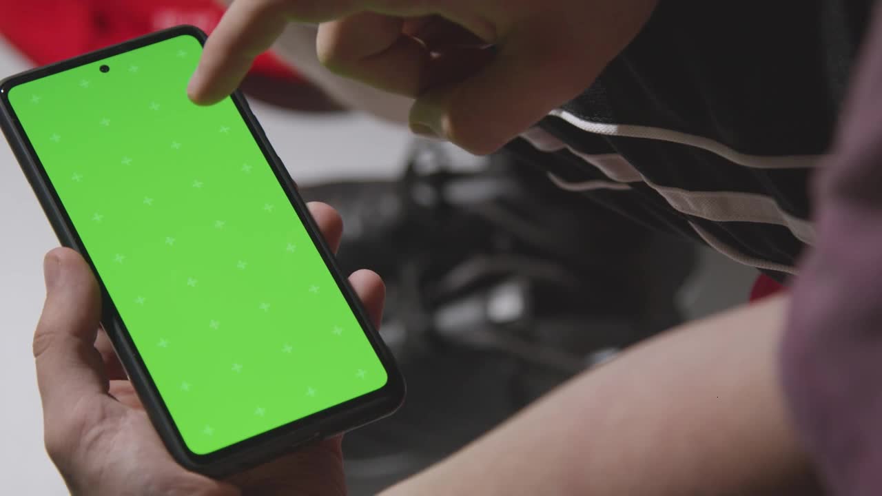 Close Up Of Man In Dressing Room Ready For Football Soccer Match Looking At Green Screen Mobile Phon