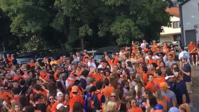 Guy orange shirt throwing beer at crowd and guy catching it