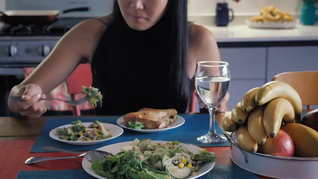 Girl eating salad in her kitchen dining room