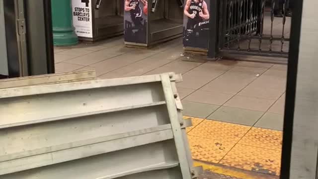 Guy carries big metal pieces into subway train