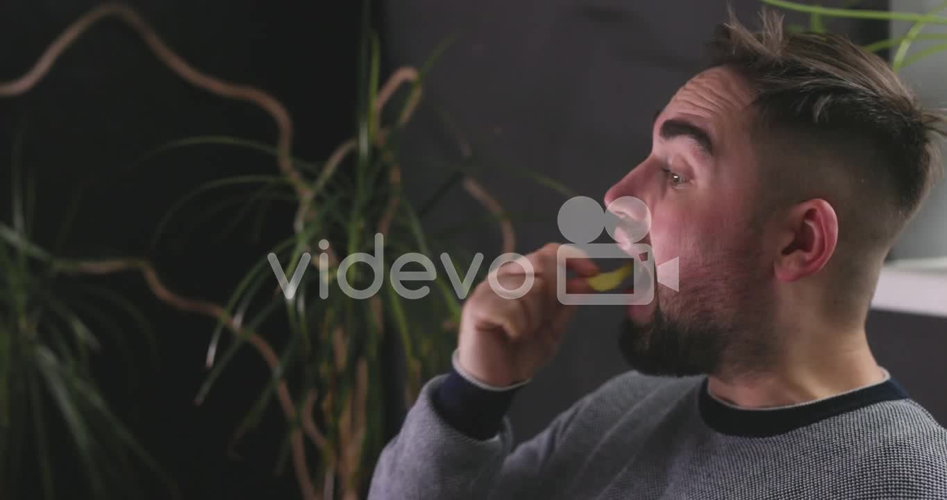 Hungry Man Sitting On Sofa And Eating Delicious Potato Chips 1