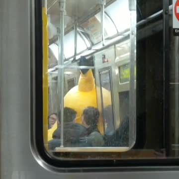 Person dressed as pikachu tapping subway doors