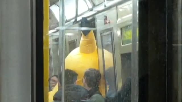 Person dressed as pikachu tapping subway doors