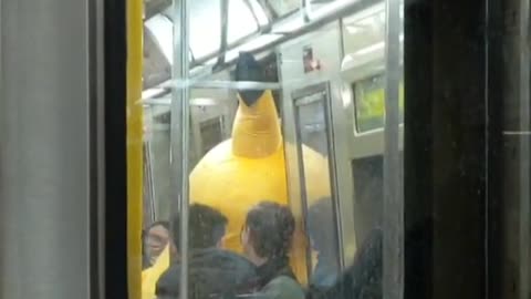Person dressed as pikachu tapping subway doors 