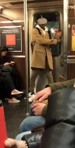 Guy wears vr headset on subway train and waves his arms around