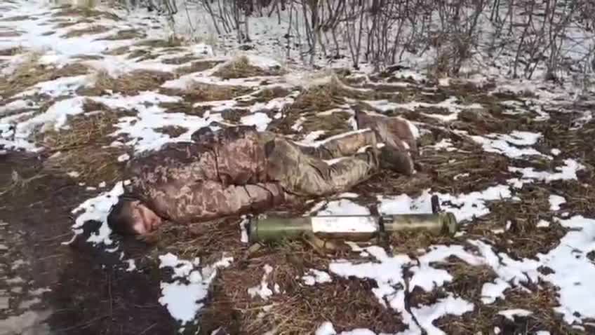 Locals pass by the killed Ukrainian soldier.