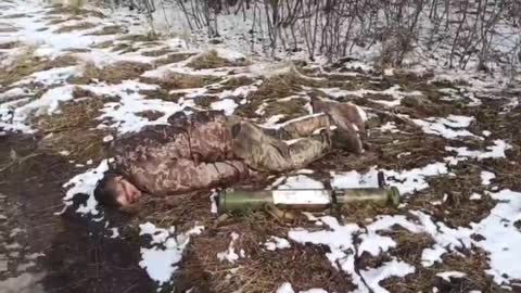 Locals pass by the killed Ukrainian soldier.
