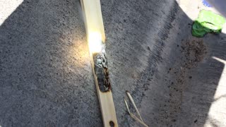 Burning wood with a magnifying glass in the sun.