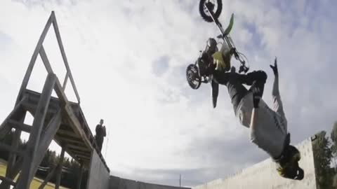 Guy motorcycle dirt bike back flip into foam pit almost gets hit by bike