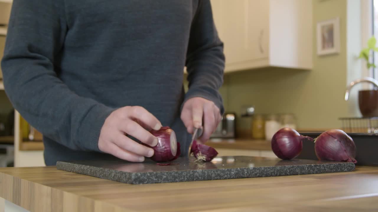 Man Chopping Onions in Kitchen