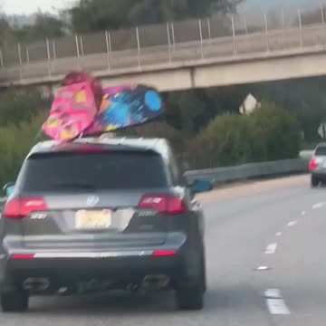 Blue and pink boogie boards on roof of car