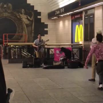 Man playing guitar several people dancing