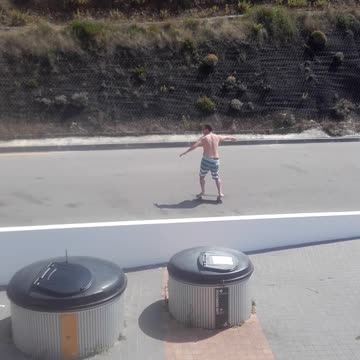 Shirtless guy blue white stripe shorts skateboarding street