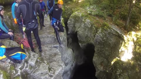 A guy falls into water in a canyon