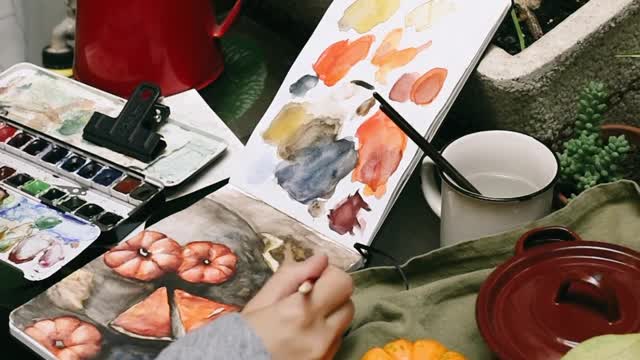 Young Woman Painting in Notebook Close up