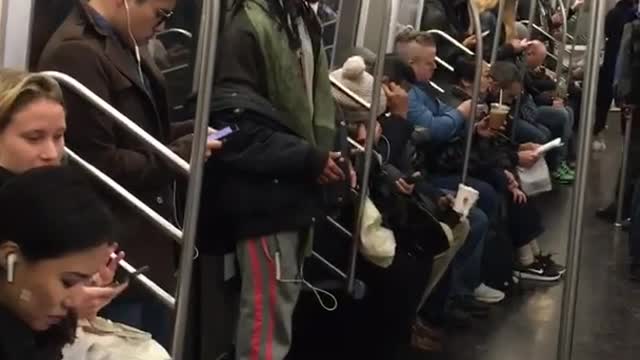 White headphones raps along to music on subway